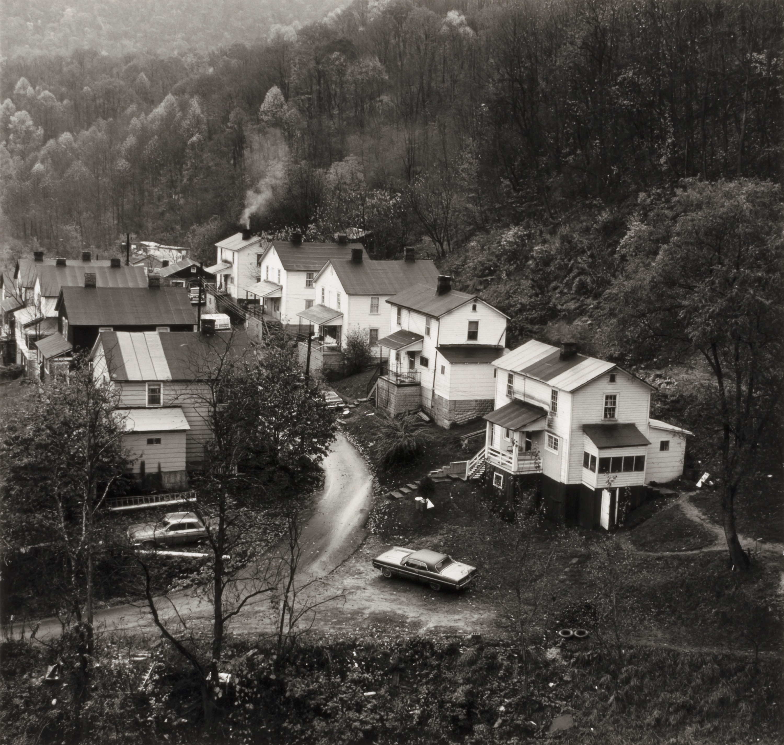 Black and white photograph of a row of houses seen from a distance.