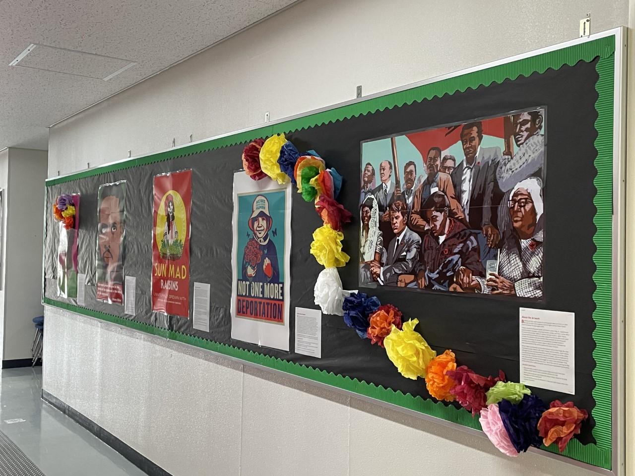 Posters on a school hallway bulletin board. They are decorated with paper flowers.