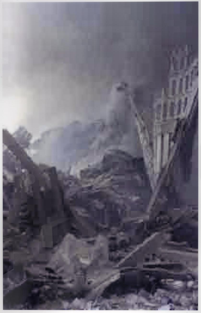 A pixelated photograph of a scene of a destroyed city. The image is in shades of gray.