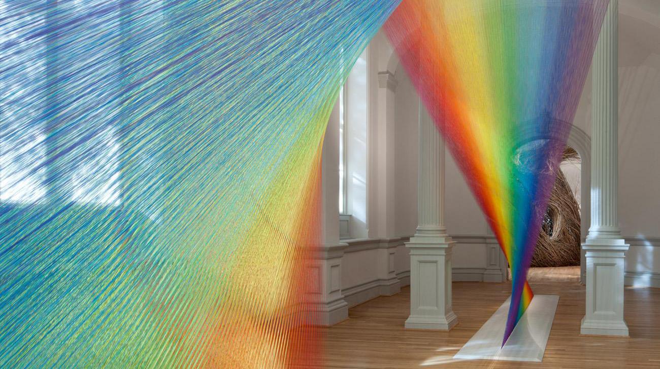 A photograph of an rainbow artwork from floor to ceiling