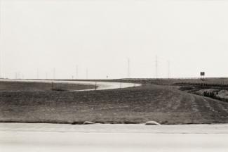 A photograph of an Ohio landscape with a road taken by automobile.