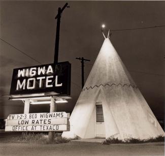 A photograph of a motel in Arizona with a teepee outside. 