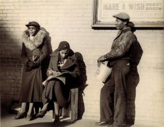 McNeill's gelatin silver print of three figures waiting against a wall.