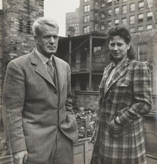 A photograph of a man and wife standing outside in coats.