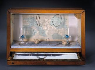 A box with a map in the background and two circles hanging from the top with two small glasses with blue balls inside.