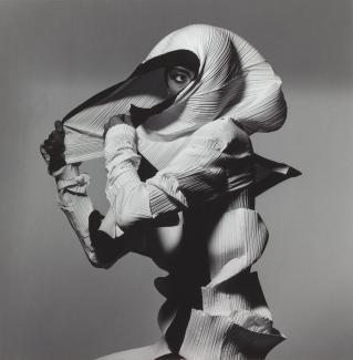 A photograph of a figure with clothing over its head. 