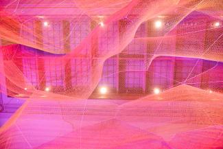 A photograph of colorful mesh hung from the ceiling inside the Grand Salon at the Renwick Gallery.