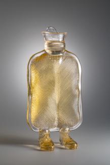 A photograph of a glass bottle with human feet. 