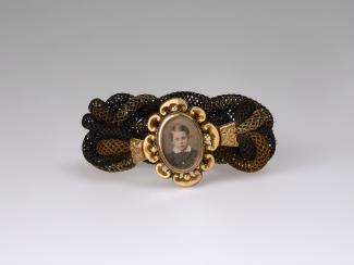 A hairband with the face of a young boy surrounded by a gold frame 