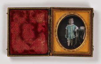 A sixth-plate daguerreotype shows a young child in a blue shirt standing