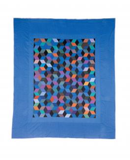 A quilt in the tumbling blocks pattern with a blue border.