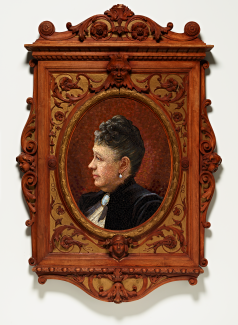 A portrait of a woman in a black dress made from glass mosaic tiles in an ornate wooden frame.