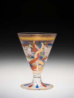 A transparent goblet with opaque red, yellow, and blue patterns.
