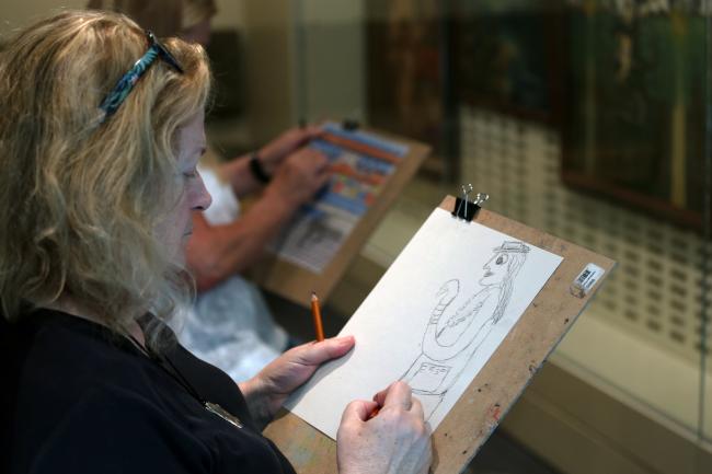 A photo of a woman sketching in the Luce Foundation Center at the Smithsonian American Art Museum.