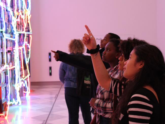 A picture of k-12 students in front of Nam June Paik's Superhighway.