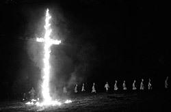 A photograph of a KKK burning of a cross