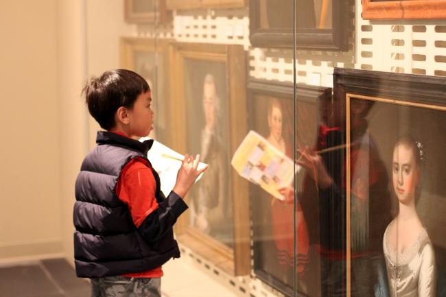 A boy doing a scavenger hunt at the Luce Foundation Center.