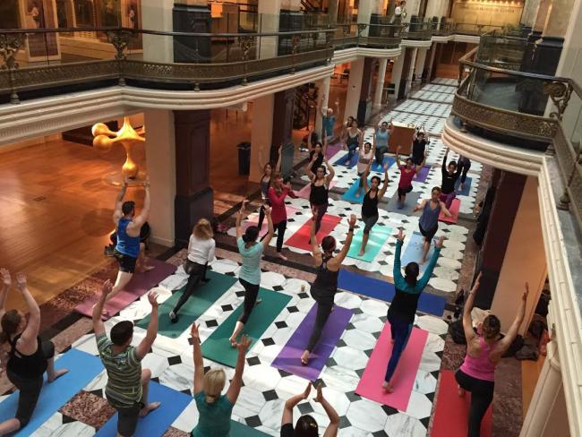 An image inside the Luce Foundation Center with people practicing yoga on the ground floor.