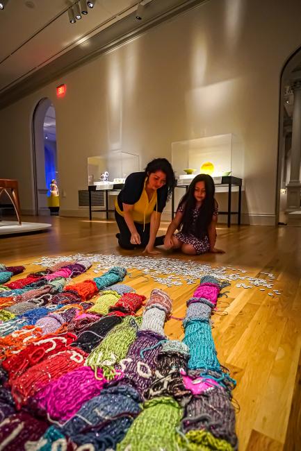 A woman and her daughter look at artwork on the floor of the Renwick Gallery