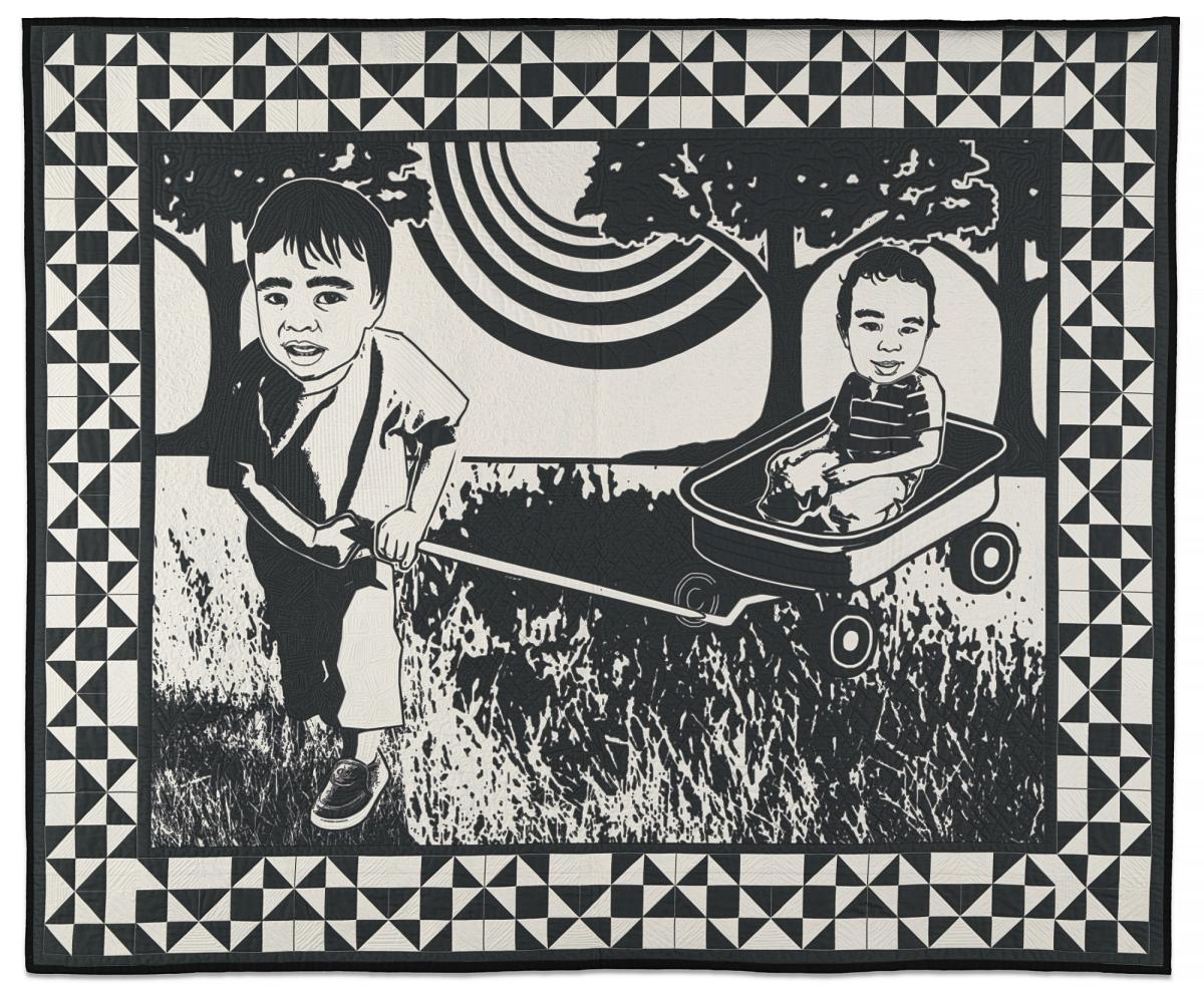 Black and white quilt of two children with a patchwork border.