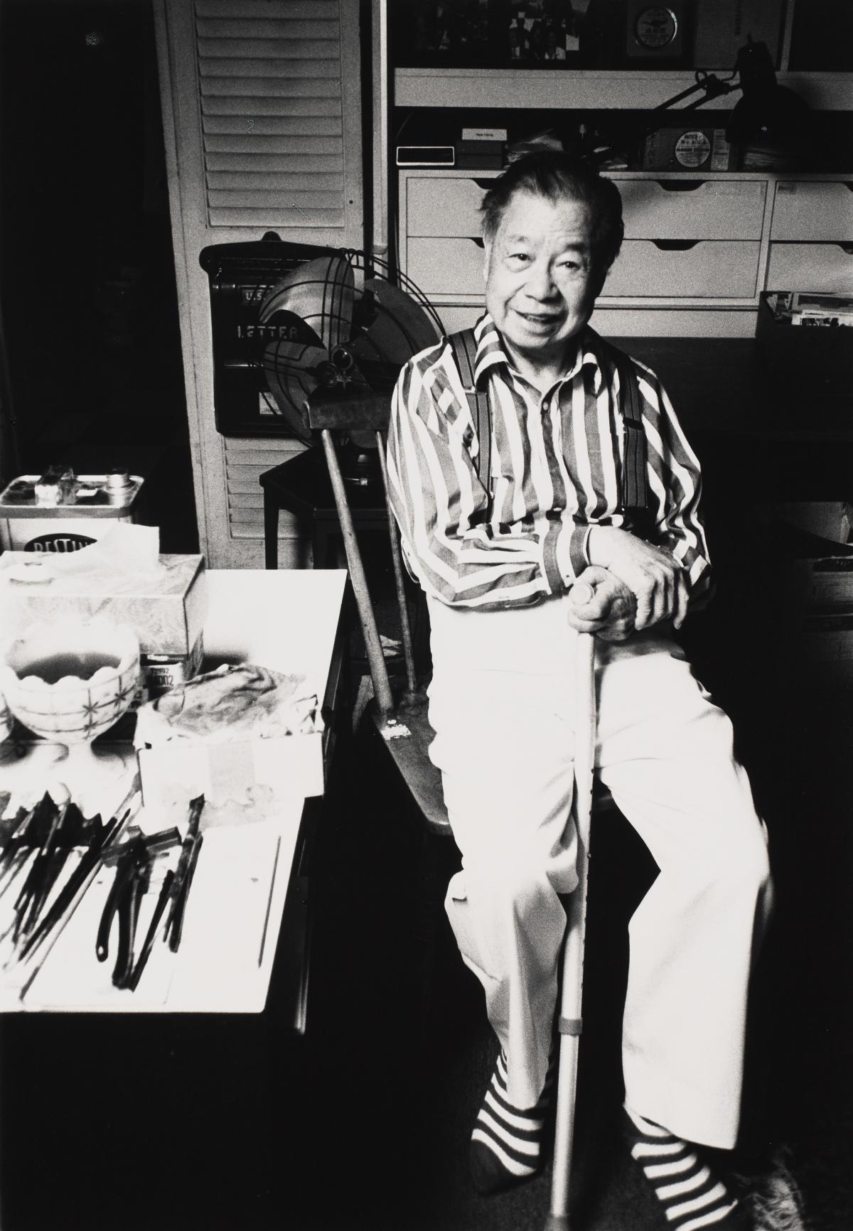 Photo of person seated in chair holding a cane