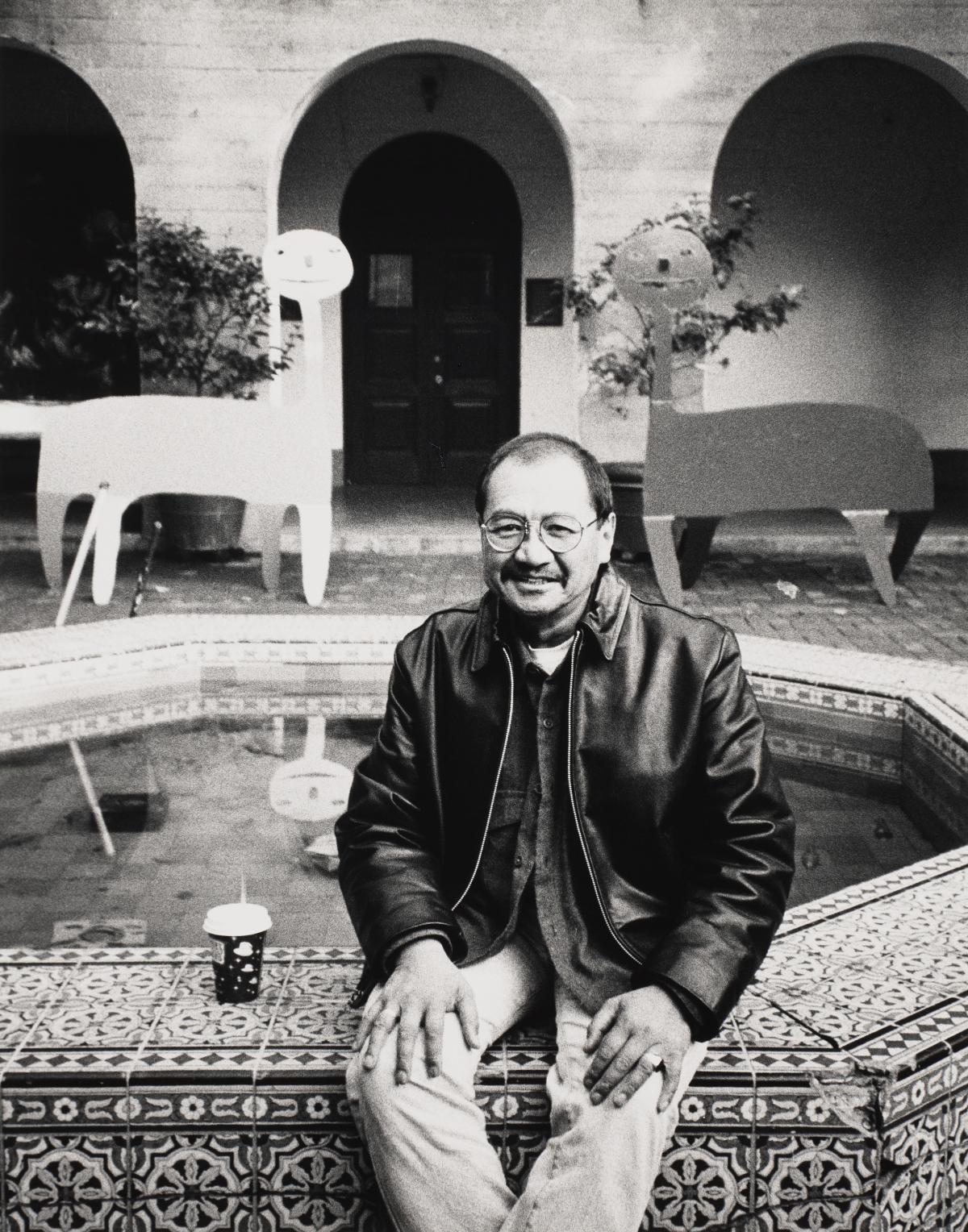 photo of person sitting on edge of a fountain