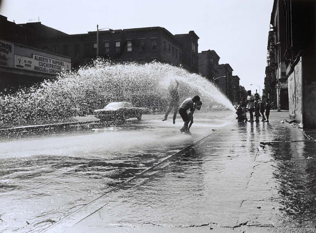 Photograph of children playing in the water from a fire hydrant by Hiram Maristany