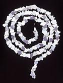 This is a white necklace that is curved in the shape of a snake. 