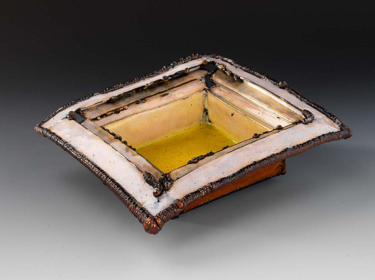 Ceramic square structure with yellow interior base with lighter top and red exterior coloring. 