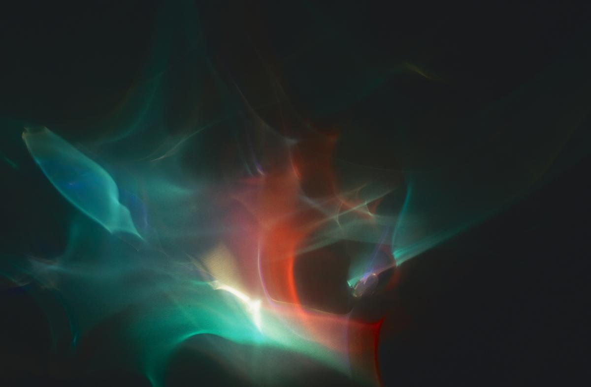 A study of light with green, orange, red, an yellow tones.