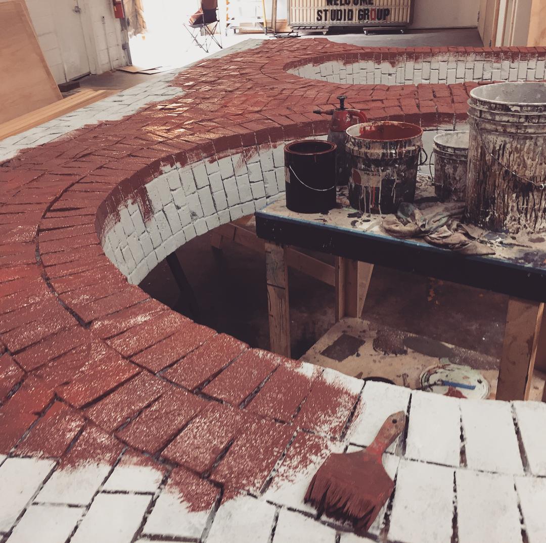 Photo of a faux brick archway being painted red