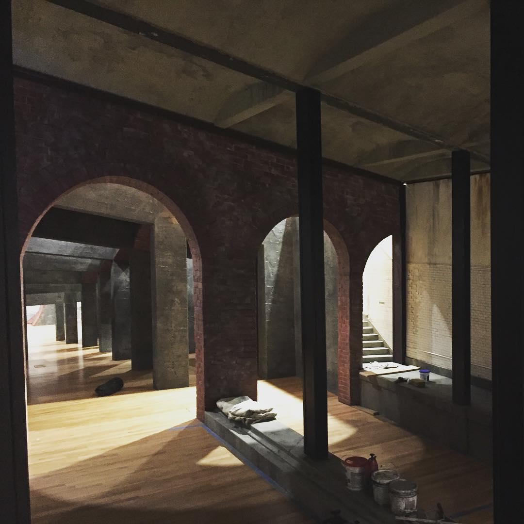 Photo of a dark room with arches and supporting beams