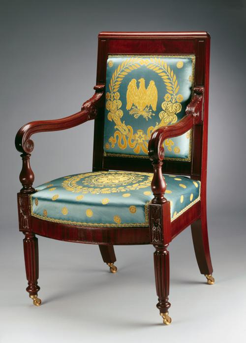 An image of a mahogany armchair with blue and gold upholstery 