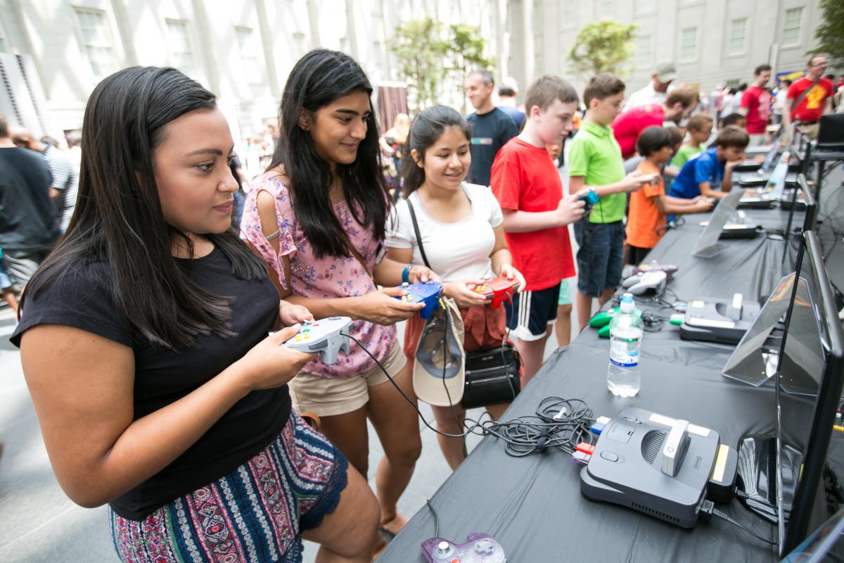 SAAM Arcade attendees playing video games in the Kogod Courtyard.
