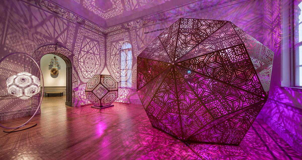 A picture of three sculpture pieces that light up and fill a room with shapes and shadows. 