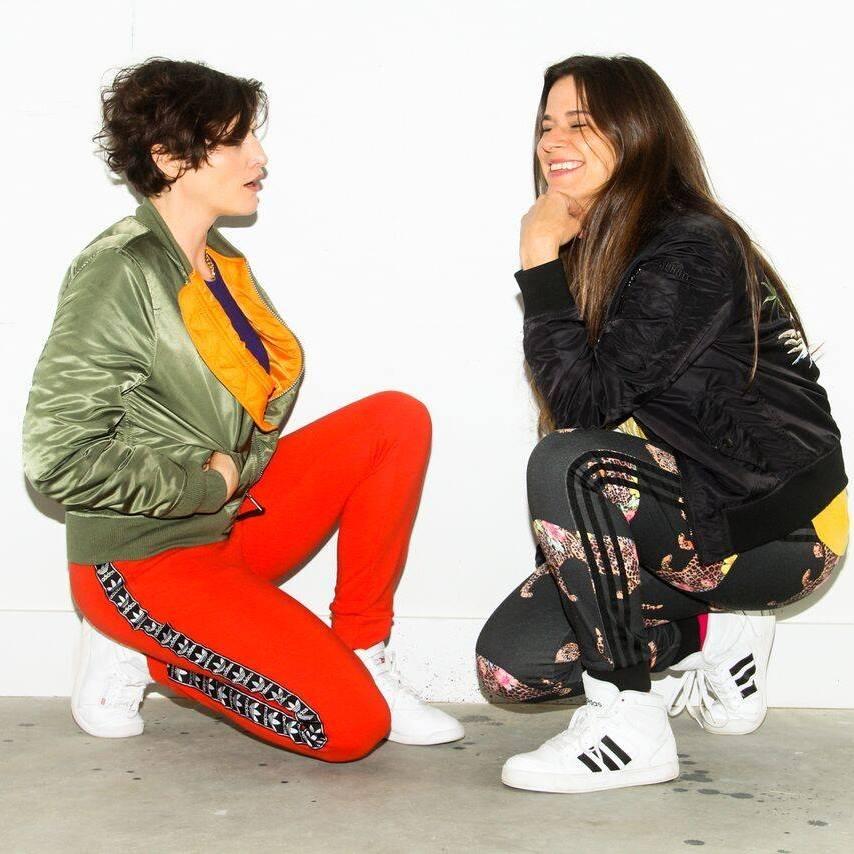 An image of two girls sitting on the floor looking at each other.