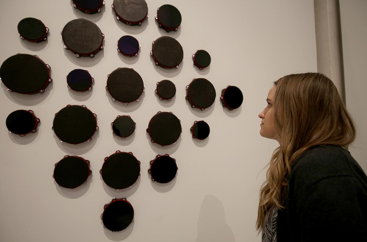 A photograph of a figure looking at Requiem for Charleston at the Smithsonian American Art Museum.