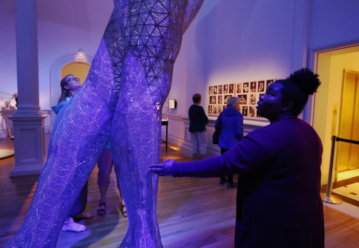 A picture of a woman touching the legs of a large sculpture piece at the Renwick Gallery.