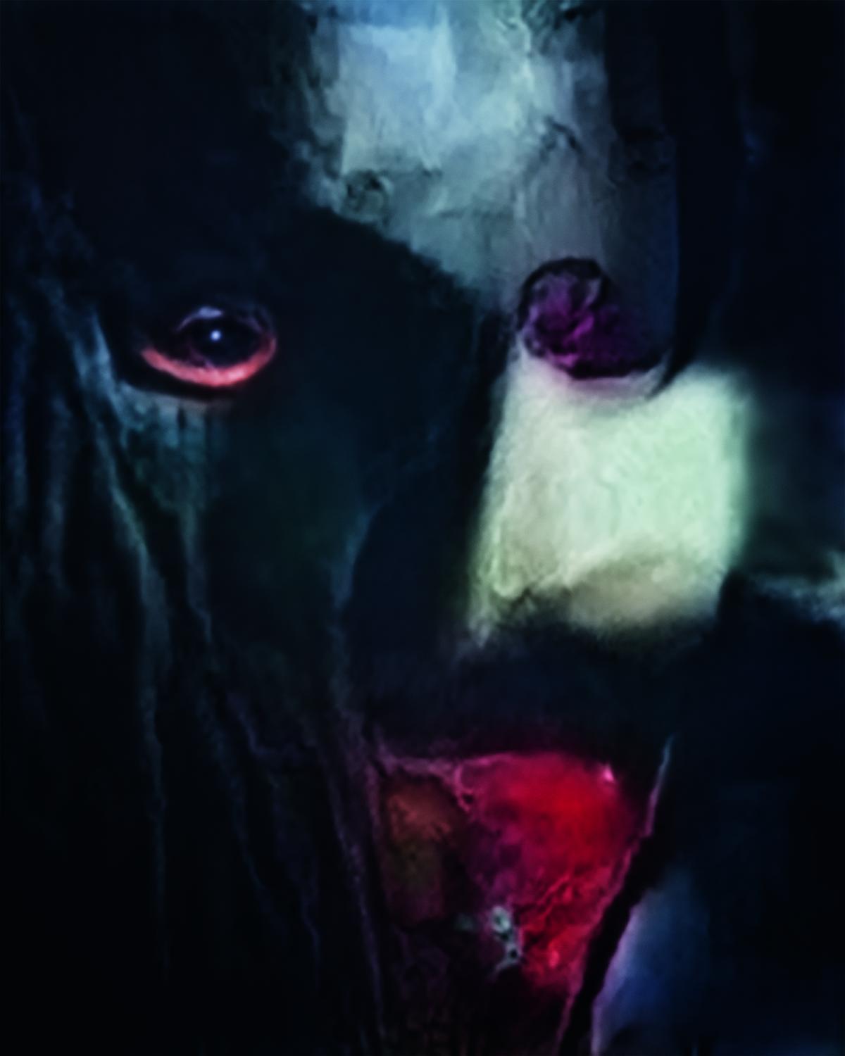 A photograph of a figure in a black mask with a red mouth.