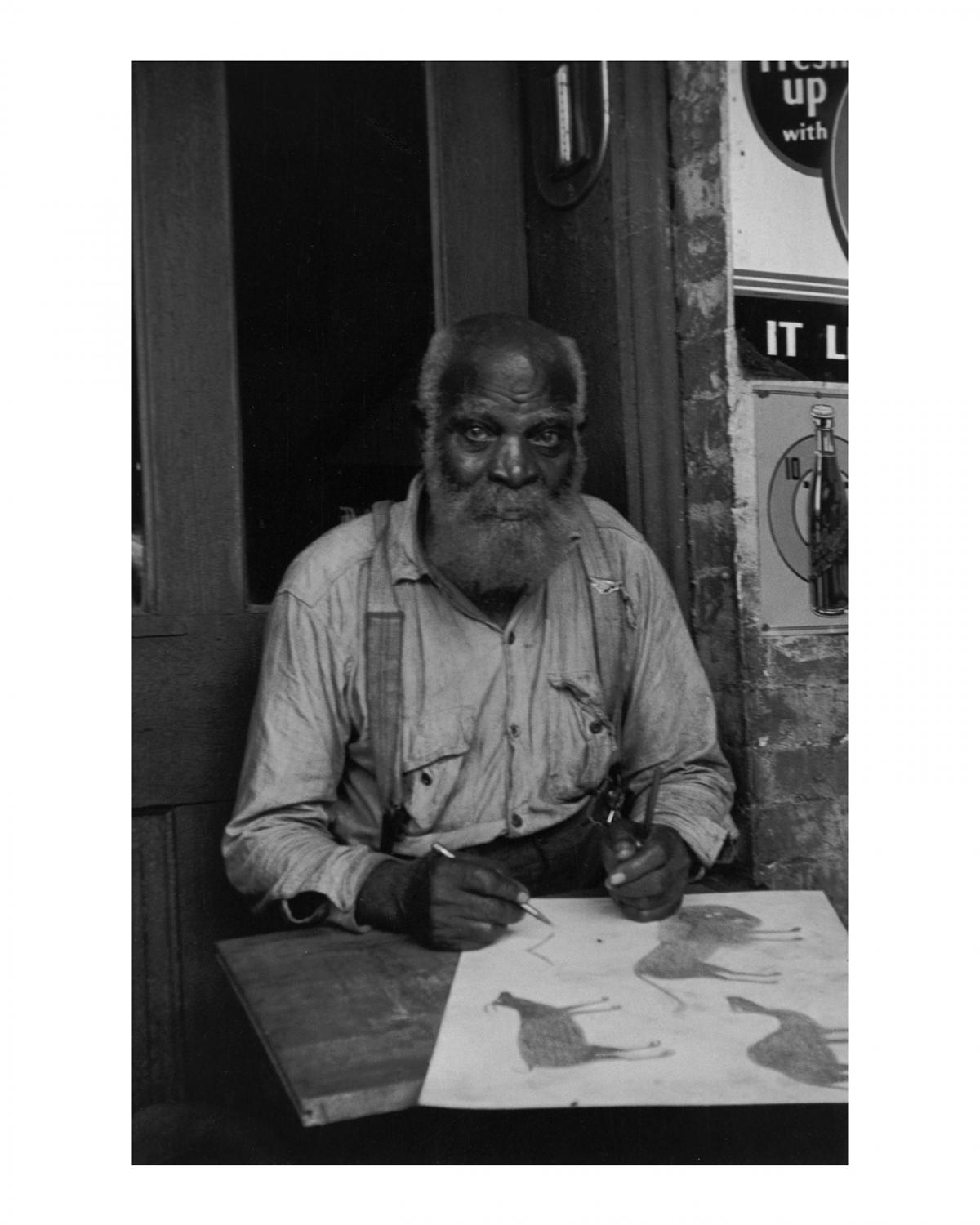 This is an image of artist Bill Traylor sitting at a table.