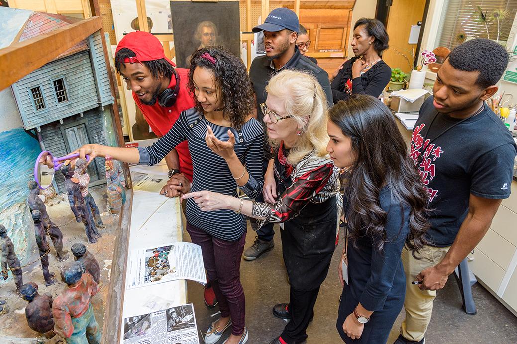 An image of young adults gathered around an artwork