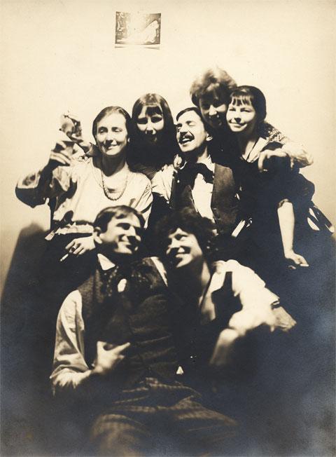 A photo of seven people laughing and smiling. 
