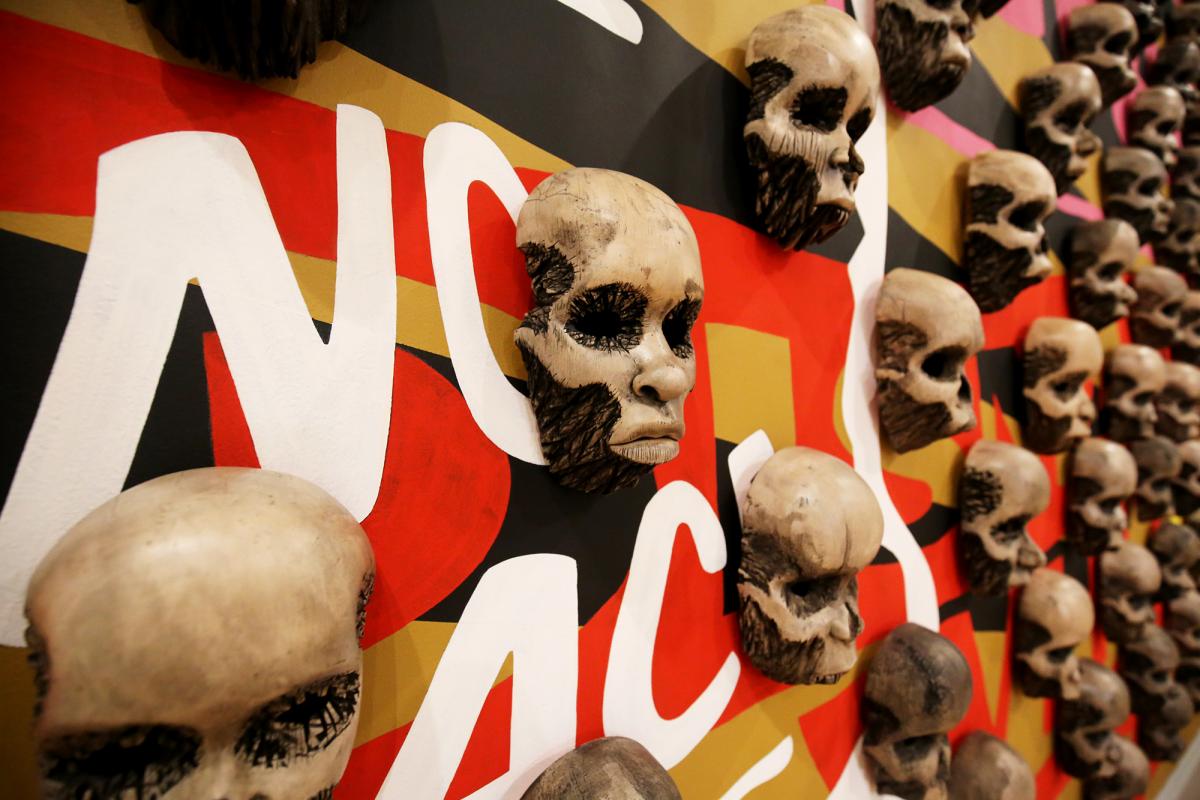 A detailed photograph of wood carved skulls on a wall.