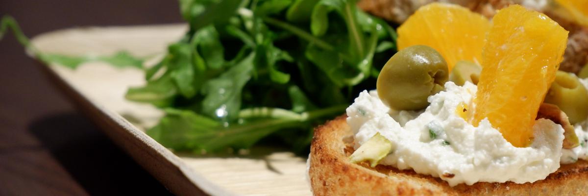 A photograph of toast with fruit and cream. 