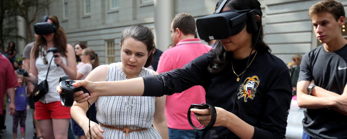 A photograph of a girl playing a game with a VR headset on. 