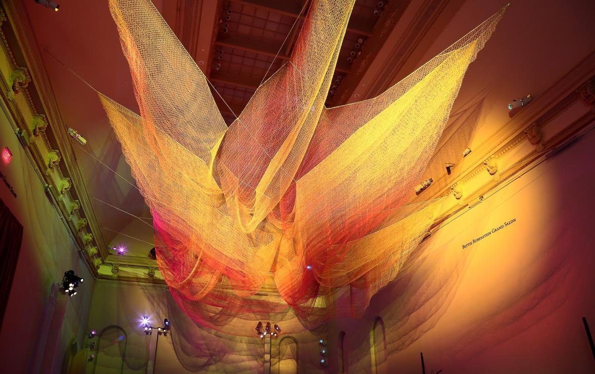 A photograph of colorful mesh hung from the ceiling inside the Grand Salon at the Renwick Gallery.