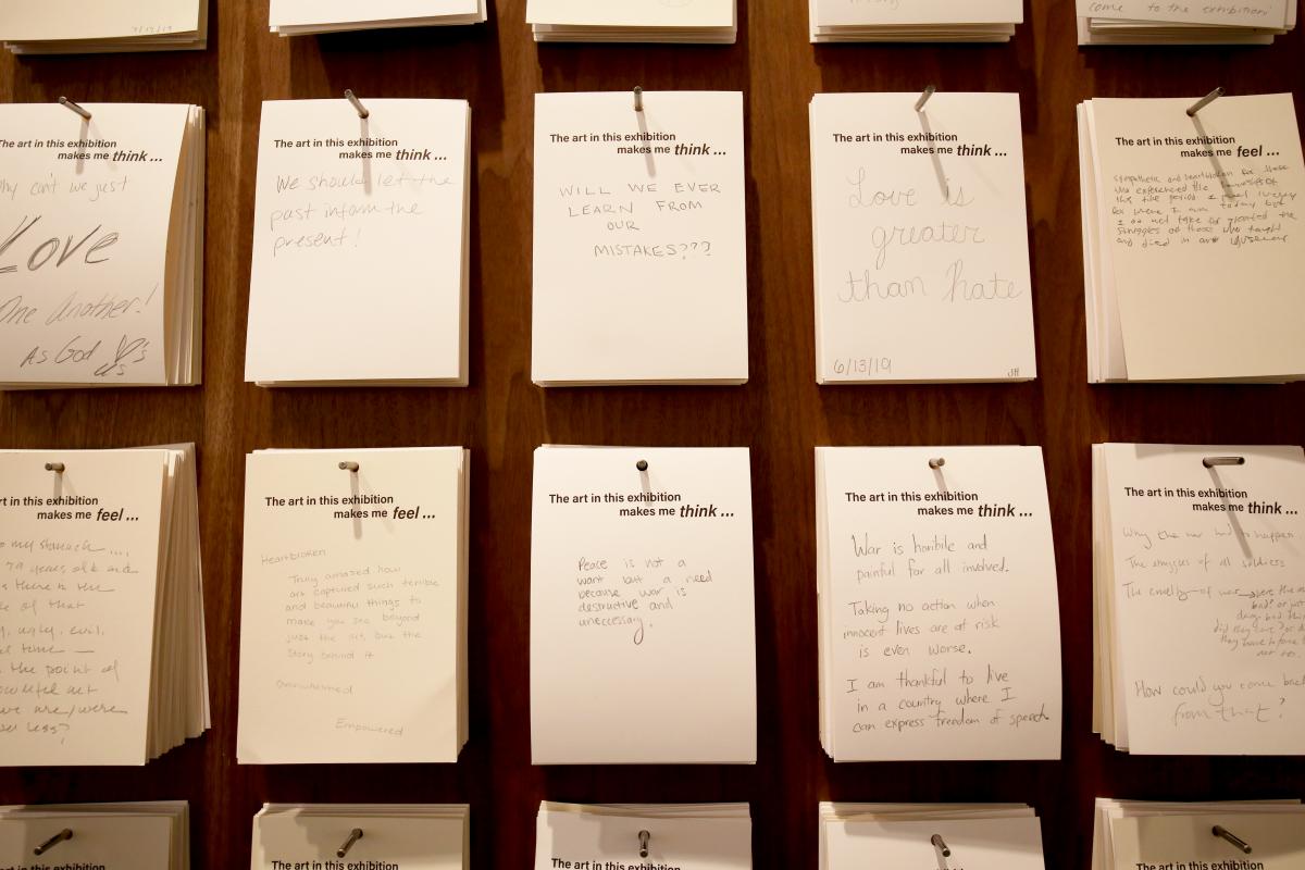 A photograph of a wall with a sign that says "This exhibition makes me feel..."