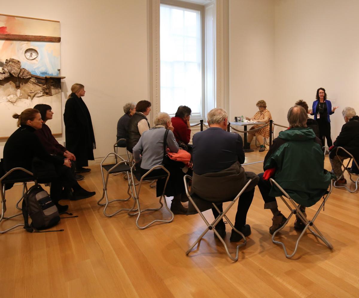 A research fellow talks to an audience about Duane Hanson's Woman Eating