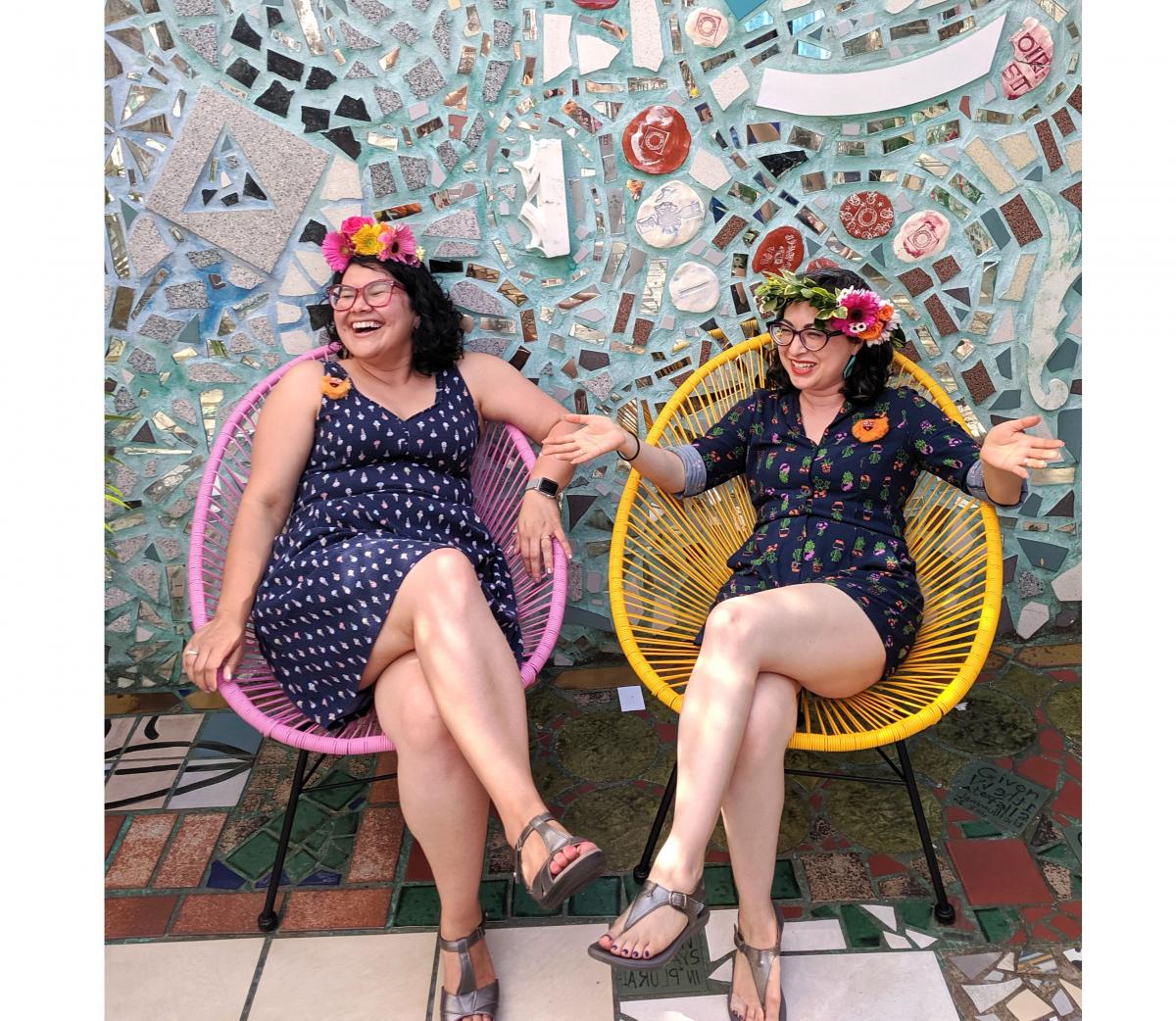 A photo of two women sitting on chairs laughing. 