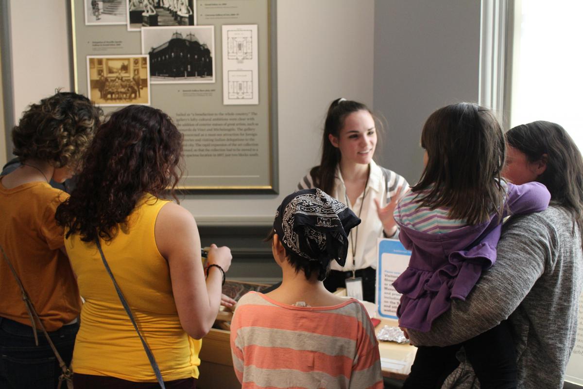 A group of children talking to one another inside a building.